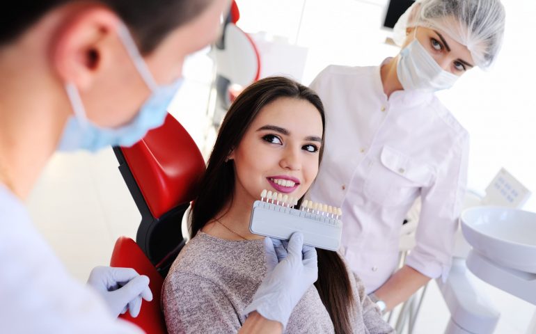 cute young girl in dentist's chair.the selection of the color of teeth